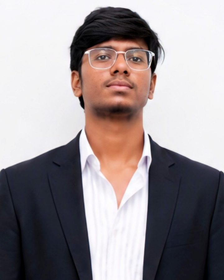 Portrait of Balaji M in a black blazer and white shirt, wearing glasses